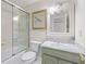 Traditional bathroom featuring a tub with glass doors, marble countertops and plenty of natural light at 9570 Huntcliff Trce, Atlanta, GA 30350