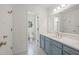 Bathroom with hexagon patterned tile flooring, light blue vanity with a large framed mirror at 9570 Huntcliff Trce, Atlanta, GA 30350