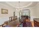 Formal dining room featuring hardwood floors, a large wood table, elegant lighting, and wainscoting at 9570 Huntcliff Trce, Atlanta, GA 30350