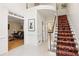 Bright foyer with staircase with carpet runner, white trim and tile floors at 9570 Huntcliff Trce, Atlanta, GA 30350