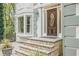 Close up of the entry with a decorative wooden front door and stone steps at 9570 Huntcliff Trce, Atlanta, GA 30350