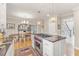 Spacious kitchen featuring a central island, stainless steel appliances, hardwood floors, and modern lighting at 9570 Huntcliff Trce, Atlanta, GA 30350