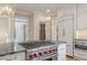 Gourmet kitchen with a cooktop island, stainless steel appliances, wine cooler, and custom cabinetry at 9570 Huntcliff Trce, Atlanta, GA 30350