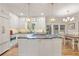 Modern kitchen with an island cooktop, stainless steel appliances, pendant lights, and access to the dining area at 9570 Huntcliff Trce, Atlanta, GA 30350