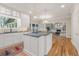 Bright kitchen with an island cooktop, white cabinets, granite counters, pendant lighting, and hardwood floors at 9570 Huntcliff Trce, Atlanta, GA 30350