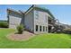 Sprawling green backyard with a grey home exterior and stairs to the deck above at 2720 Rustic Lake Ter, Cumming, GA 30041