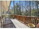 Exterior view of a cozy wooden deck with a wooden railing overlooking a lush backyard with mature trees at 2484 Oldfield Nw Rd, Atlanta, GA 30327