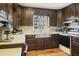 Traditional kitchen with dark wood cabinets, white countertops, and stainless-steel sink and appliances at 2484 Oldfield Nw Rd, Atlanta, GA 30327
