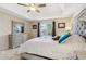Bright bedroom featuring a ceiling fan, neutral tones and a decorative dresser with mirror at 684 Old Cumming Rd, Sugar Hill, GA 30518