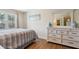 Comfortable bedroom with hardwood floors, a decorative dresser, and a large window with a view of trees at 684 Old Cumming Rd, Sugar Hill, GA 30518