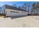Three-car garage with a long driveway and a neatly maintained exterior at 684 Old Cumming Rd, Sugar Hill, GA 30518