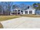 Stunning two-story home featuring a large front lawn and elongated driveway at 684 Old Cumming Rd, Sugar Hill, GA 30518