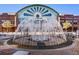 Circular fountain outside shopping pavillion, framed by brick buildings and blue sky at 684 Old Cumming Rd, Sugar Hill, GA 30518