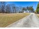 Long driveway leads up to a well-maintained two-story home with an expansive front lawn at 684 Old Cumming Rd, Sugar Hill, GA 30518