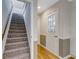 Hallway with carpeted stairs leading to a bright entryway featuring a door with glass and wood floors at 684 Old Cumming Rd, Sugar Hill, GA 30518