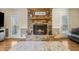 Inviting living room with stone fireplace, hardwood floors, and doors leading to the outdoor space at 684 Old Cumming Rd, Sugar Hill, GA 30518