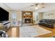 Bright living room with a stone fireplace, hardwood floors, and access to the outdoor deck at 684 Old Cumming Rd, Sugar Hill, GA 30518