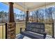 Covered front porch with wooden swing overlooking the landscaped yard at 684 Old Cumming Rd, Sugar Hill, GA 30518