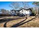 View of the home's rear exterior featuring a deck, steps, and a spacious lawn with mature trees, providing ample outdoor space at 2411 Fair Lane Ln, Decatur, GA 30032