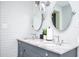 Stylish bathroom featuring double vanity with a marble countertop and round mirrors at 2411 Fair Ln, Decatur, GA 30032
