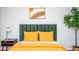 Stylishly decorated bedroom featuring an eye-catching headboard, sunny yellow bedspread, and lively potted greenery at 2411 Fair Ln, Decatur, GA 30032