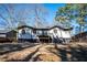 Backyard view of home with deck and spacious grassy area surrounded by mature trees creating a peaceful setting at 2411 Fair Ln, Decatur, GA 30032