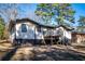 Exterior of home from backyard showing deck, stairway, spacious yard, and privacy from surrounding mature trees at 2411 Fair Ln, Decatur, GA 30032