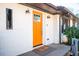 Inviting home exterior featuring a bright orange front door, white brick, and stylish light fixtures at 2411 Fair Ln, Decatur, GA 30032