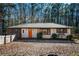 Charming, single-story home featuring a bright orange front door, white painted brick, and a well-maintained front yard at 2411 Fair Ln, Decatur, GA 30032