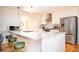 Modern kitchen featuring white cabinets, stainless steel appliances, a stylish island with bar seating, and an open layout at 2411 Fair Ln, Decatur, GA 30032