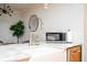 Bright kitchen featuring a farmhouse sink, modern faucet, stainless steel microwave, and white marble countertops at 2411 Fair Ln, Decatur, GA 30032