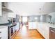 Bright, open kitchen with white cabinets, stainless steel appliances, hardwood floors, and an island with a farmhouse sink at 2411 Fair Ln, Decatur, GA 30032