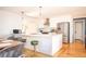 Bright open kitchen with white cabinets, a stainless steel refrigerator, and a stylish island with bar seating at 2411 Fair Ln, Decatur, GA 30032