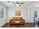 A bright and welcoming living room featuring a leather couch and a decorative ceiling fan at 3261 Lowndes St, Atlanta, GA 30337