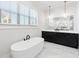 Bright bathroom featuring a soaking tub, black cabinets, and marble floors at 39 Telfair Ct, Acworth, GA 30101