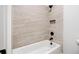 A tiled shower with a built-in shelf and matte black fixtures over a white bathtub at 39 Telfair Ct, Acworth, GA 30101