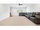 Spacious living room featuring neutral carpet, ceiling fan, and a comfortable wraparound leather sofa at 39 Telfair Ct, Acworth, GA 30101