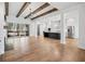 Open concept living room with hardwood floors, ceiling beams, and view into a bright kitchen at 39 Telfair Ct, Acworth, GA 30101