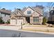 Attractive front exterior with brick and siding, a two-car garage, and landscaped front yard at 10570 Grandview Sq, Johns Creek, GA 30097