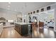 Open-concept kitchen with island seating flows into a living room, featuring hardwood floors and modern lighting at 10570 Grandview Sq, Johns Creek, GA 30097