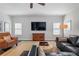 Bright living room with hardwood floors, a TV, two accent chairs and a blue leather couch at 10570 Grandview Sq, Johns Creek, GA 30097