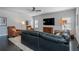 Living room with hardwood floors, TV, two accent chairs and a blue leather couch at 10570 Grandview Sq, Johns Creek, GA 30097
