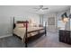 This is a large main bedroom with a ceiling fan, gray carpet and a brown, four poster bed at 10570 Grandview Sq, Johns Creek, GA 30097