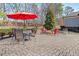 Backyard patio with pavers, fire pit, outdoor seating, and red umbrella at 10570 Grandview Sq, Johns Creek, GA 30097