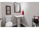 A small powder room with a pedestal sink, artwork and dark floors at 10570 Grandview Sq, Johns Creek, GA 30097