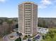 This aerial view shows the high-rise apartment building against a backdrop of leafy trees at 1501 Clairmont Rd # 1027, Decatur, GA 30033