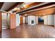 Finished basement area featuring laminate flooring, a fireplace, exposed wood beams, and a door at 3911 Ivy Ne Rd, Atlanta, GA 30342