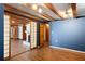 Finished basement area featuring laminate flooring, a fireplace, exposed wood beams, and a blue accent wall at 3911 Ivy Ne Rd, Atlanta, GA 30342