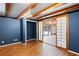 Basement living space features wood laminate flooring, wood beams, and a blue accent wall at 3911 Ivy Ne Rd, Atlanta, GA 30342