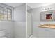 Bathroom featuring tile flooring, white walls, a shower, a window, and a sink at 3911 Ivy Ne Rd, Atlanta, GA 30342